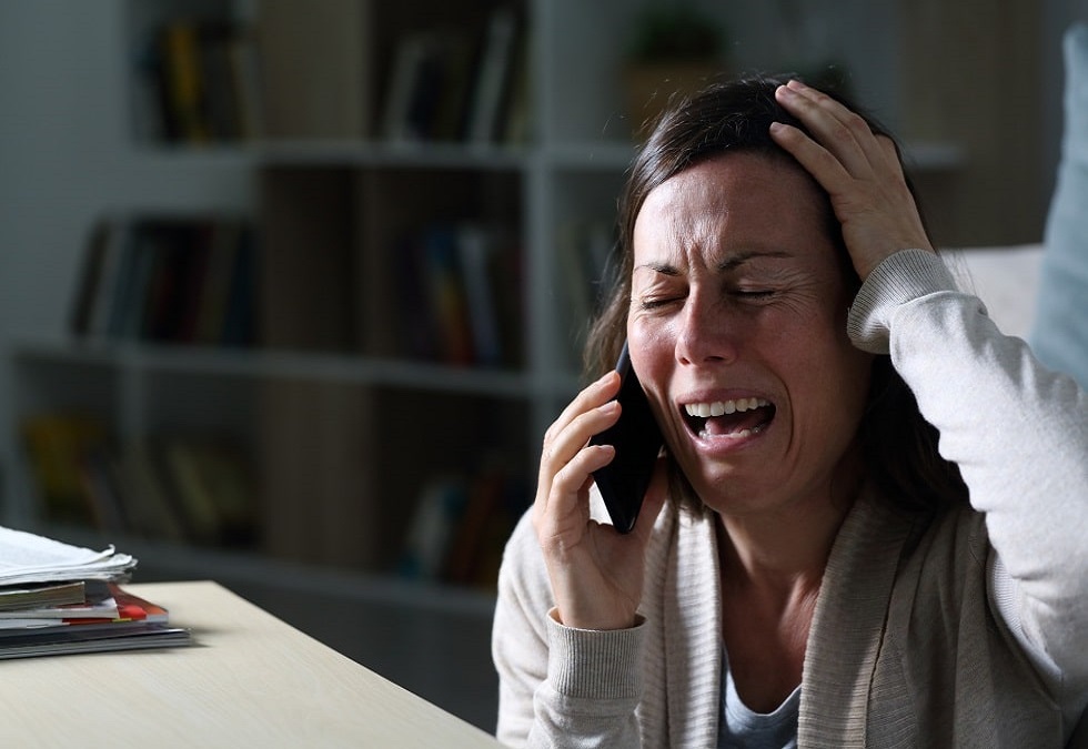 adult woman calling on phone crying at night